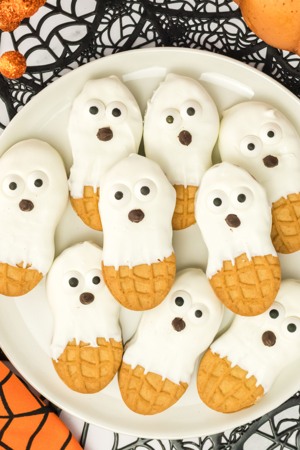 nutter butter ghost cookies on a white plate with halloween decor