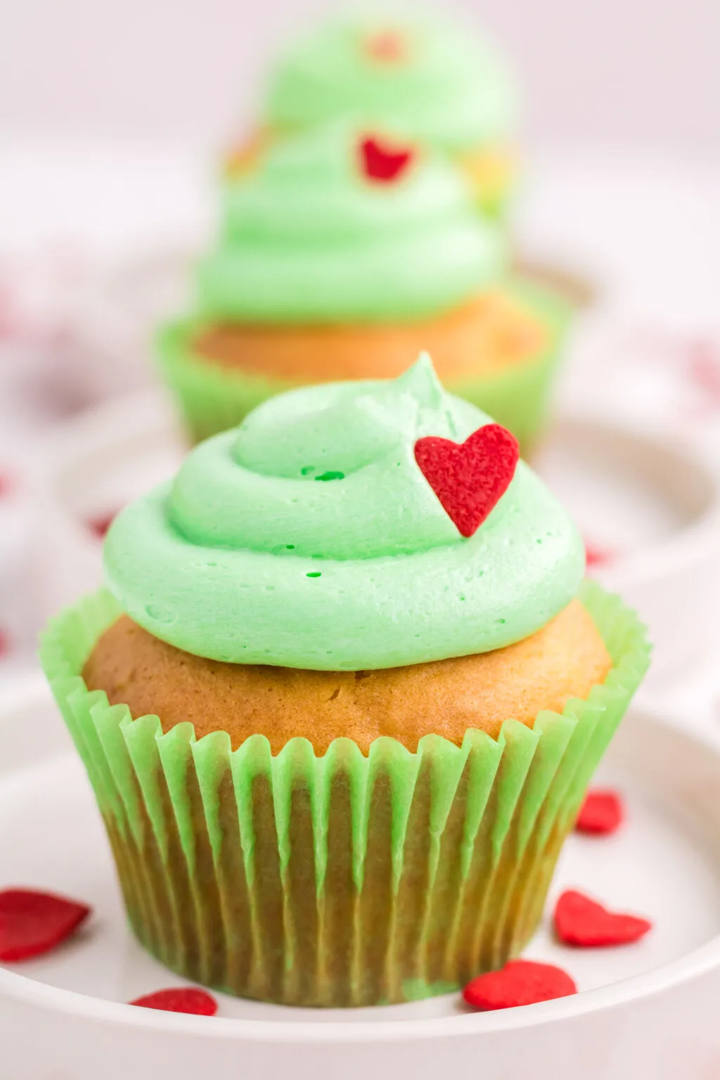 grinch cupcakes lined up on white plate