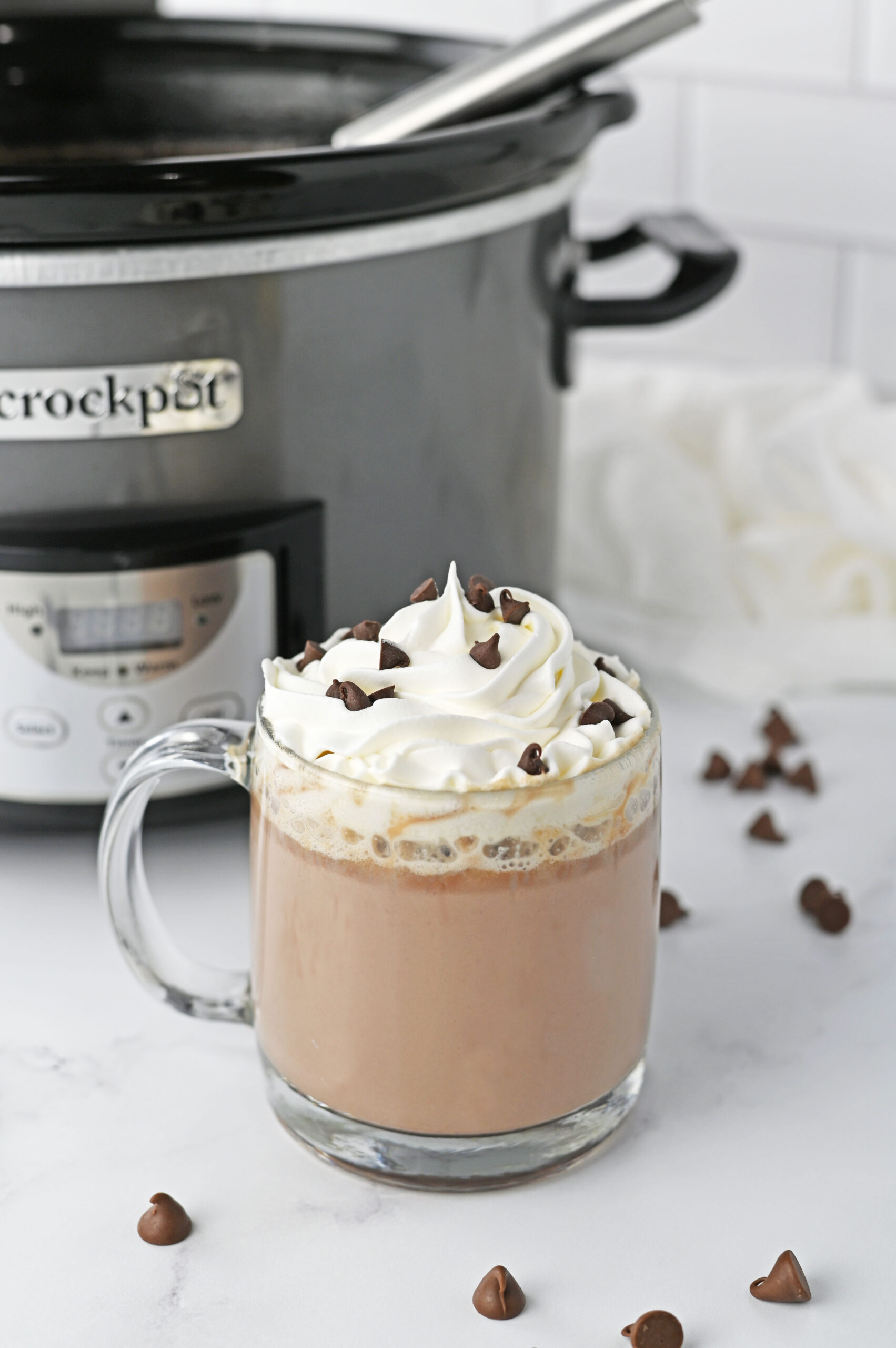 cup of slow cooker hot chocolate with whipped cream and chocolate shavings on top