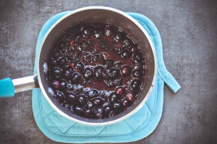 simmering blueberries and sugar in saucepan
