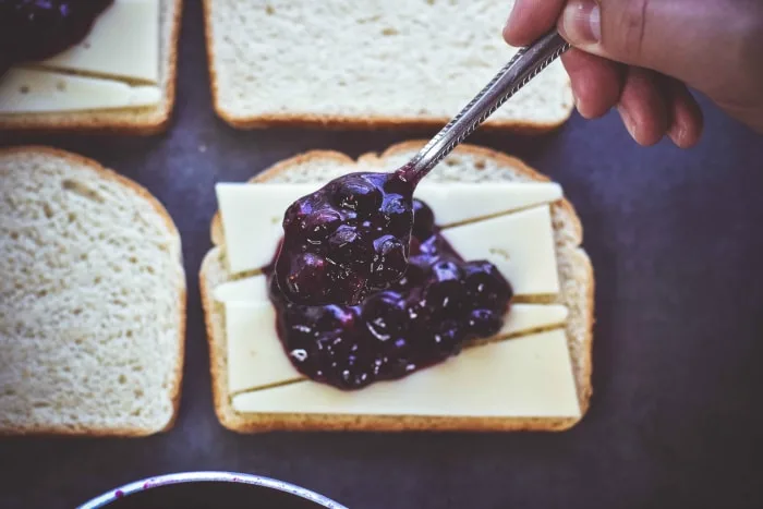 spoon putting blueberry mixture on bread