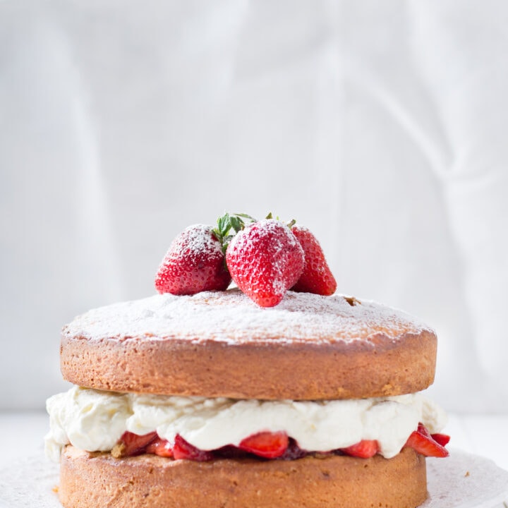 sponge cake with whipped cream and berries on a plate