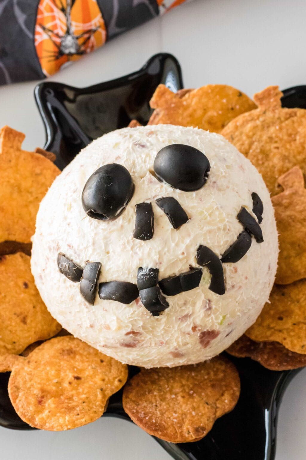a cheeseball on a plate with jack skellington's face on top