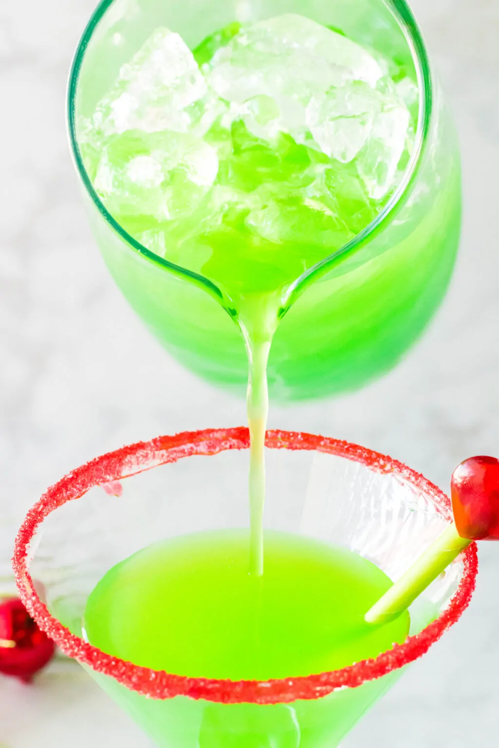 pouring grinch cocktail drink into glass