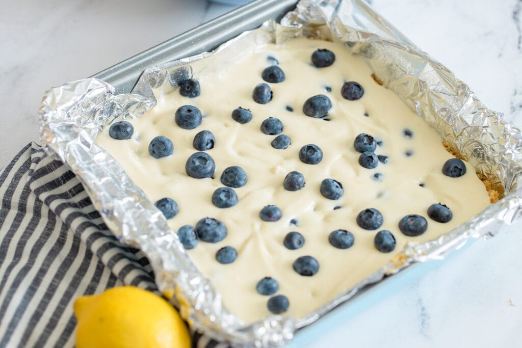 pan filled with cheesecake mixture and topped with blueberries