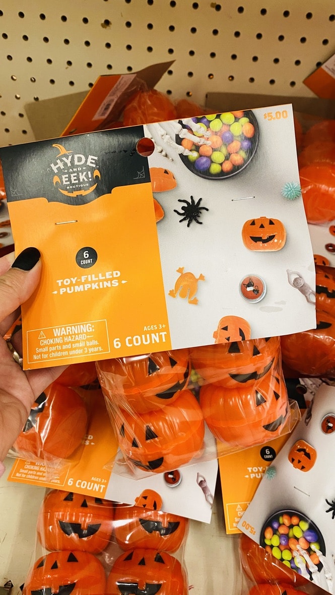 hand holding package of pumpkin halloween eggs at Target