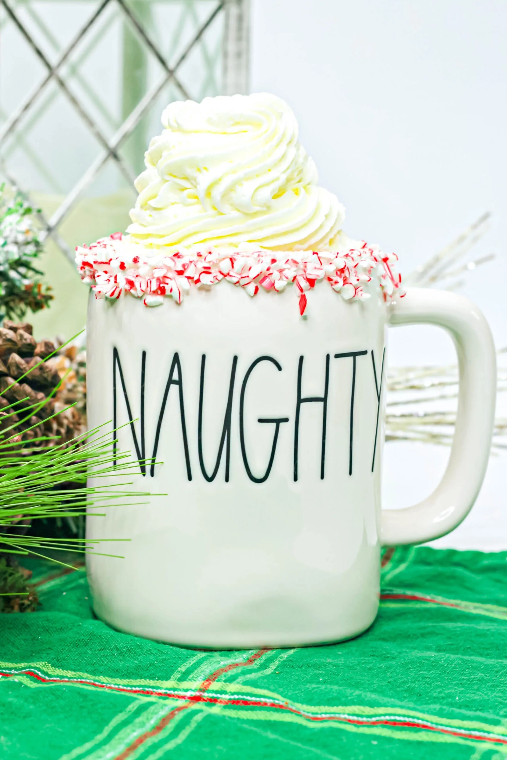 boozy peppermint hot cocoa in a mug with whipped cream on top