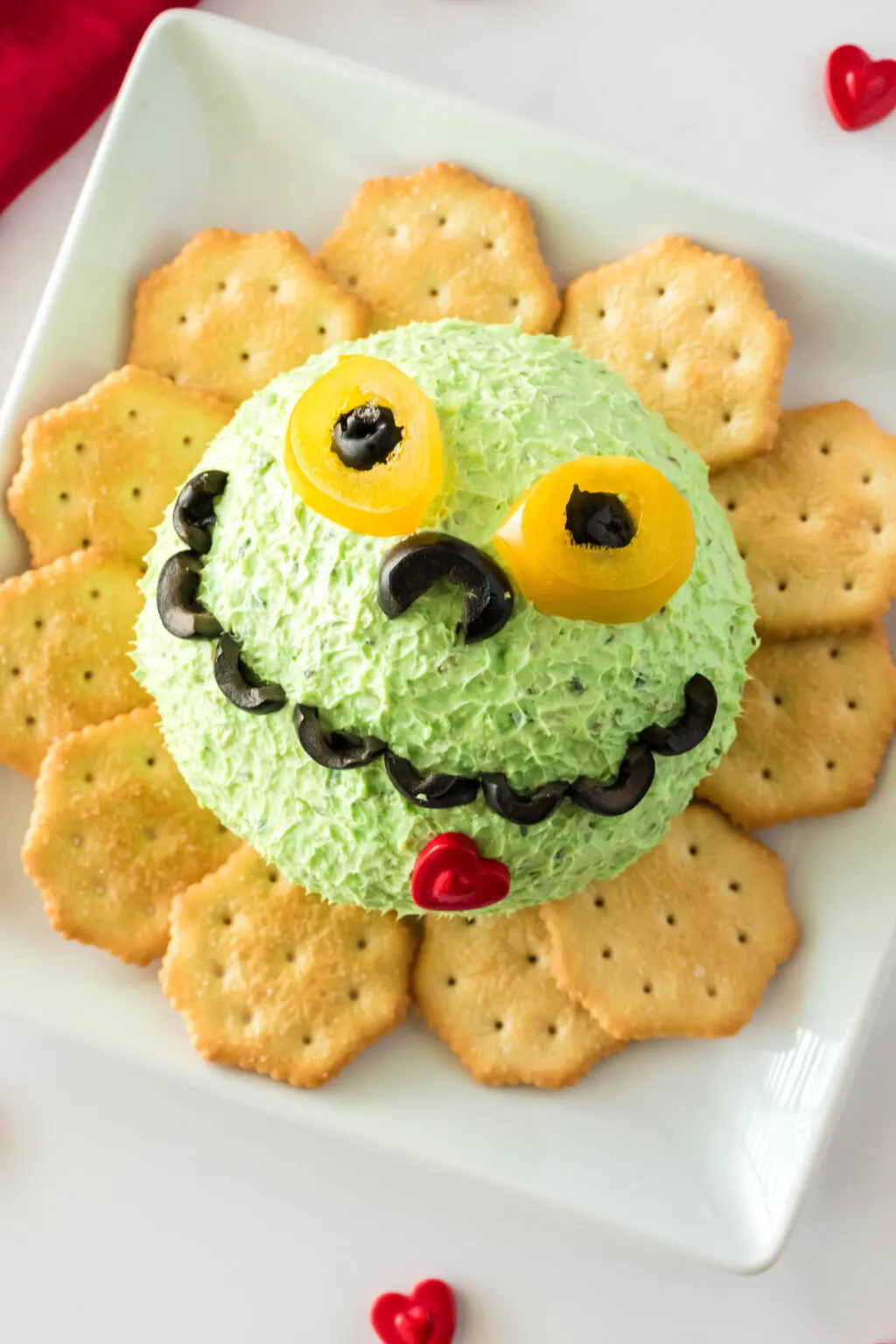 grinch cheese ball on plate with crackers