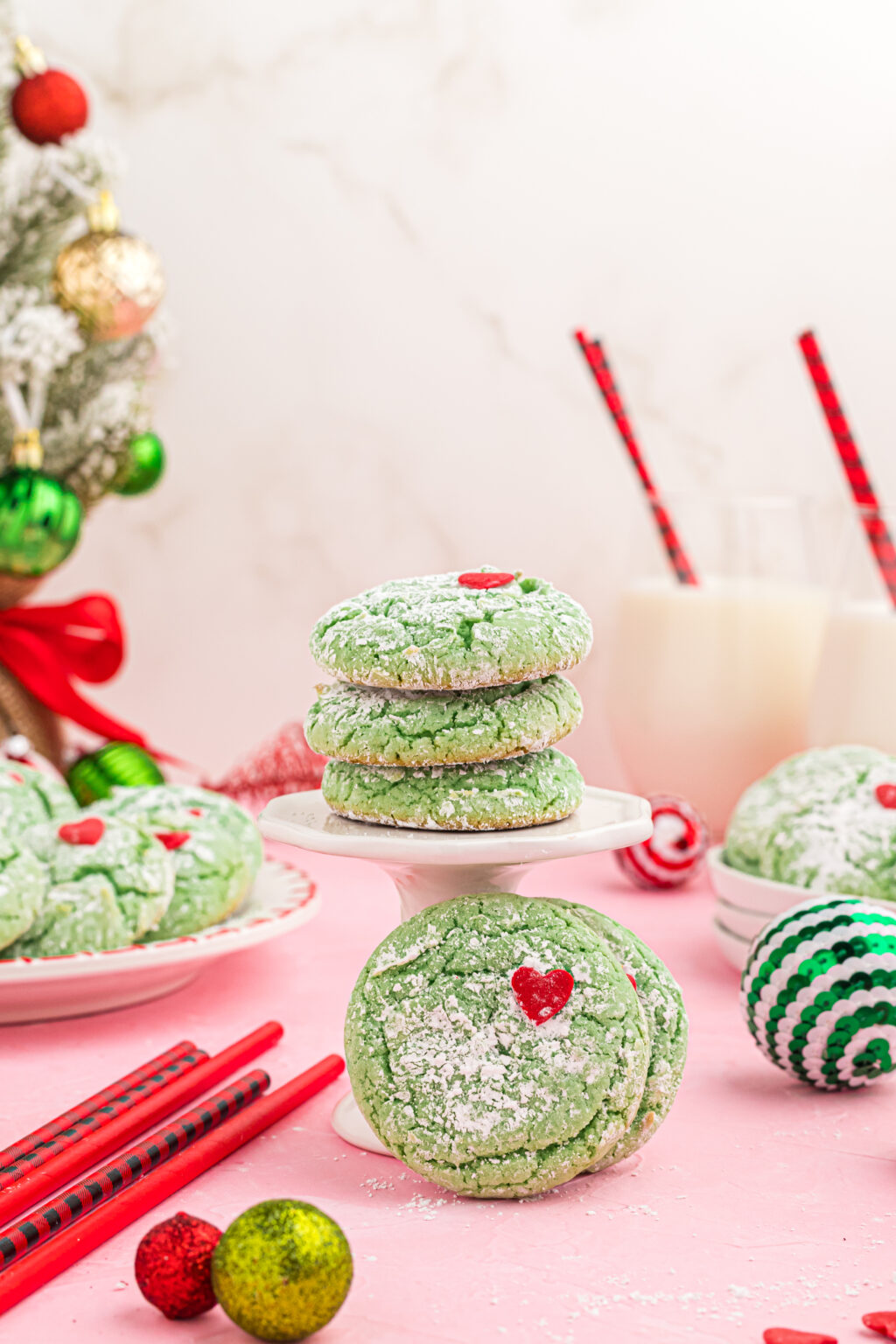grinch cookies stacked on white cookie tray