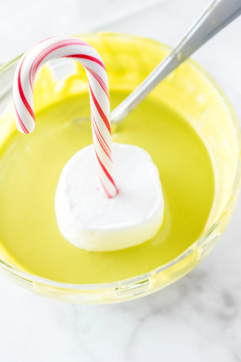 candy cane stirrer in green melted chocolate