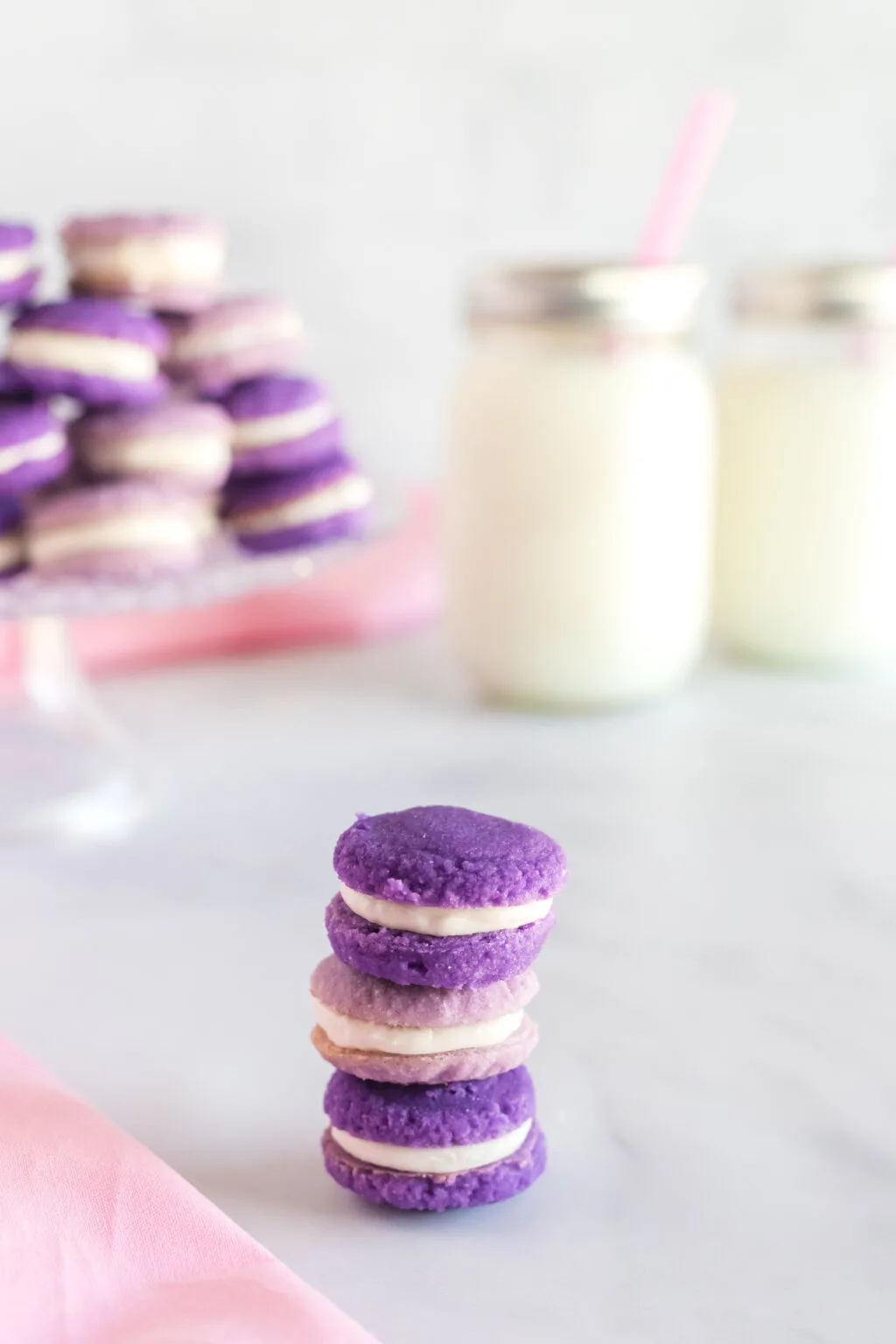 Lavender Macarons stacked on table with milk in background