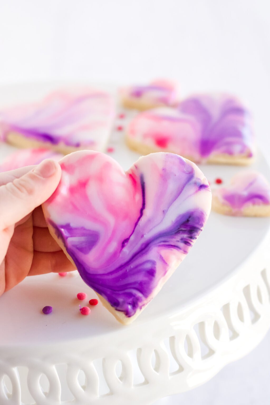 hand holding marbled heart cookie