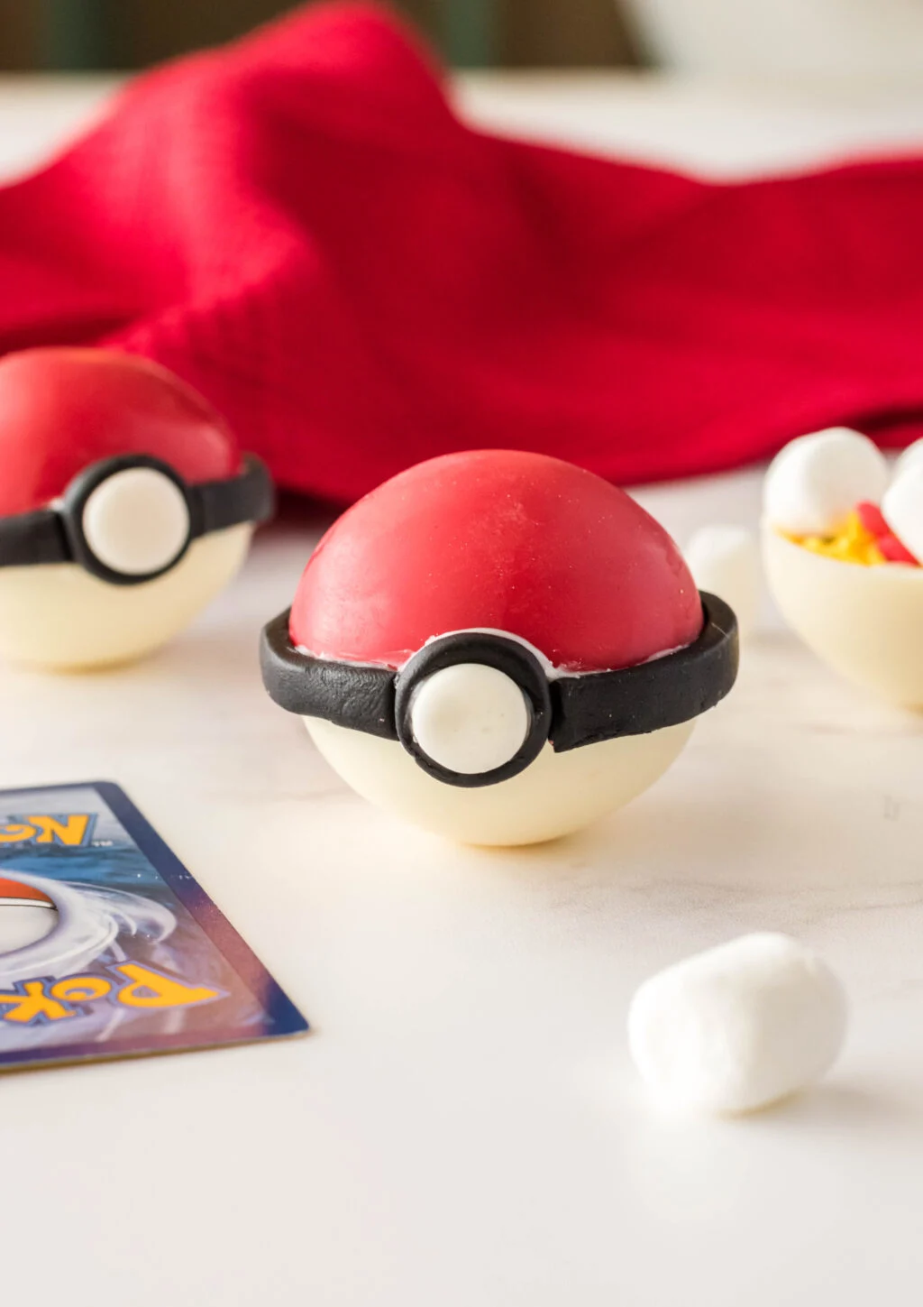 poke ball hot chocolate bomb on table with pokemon cards