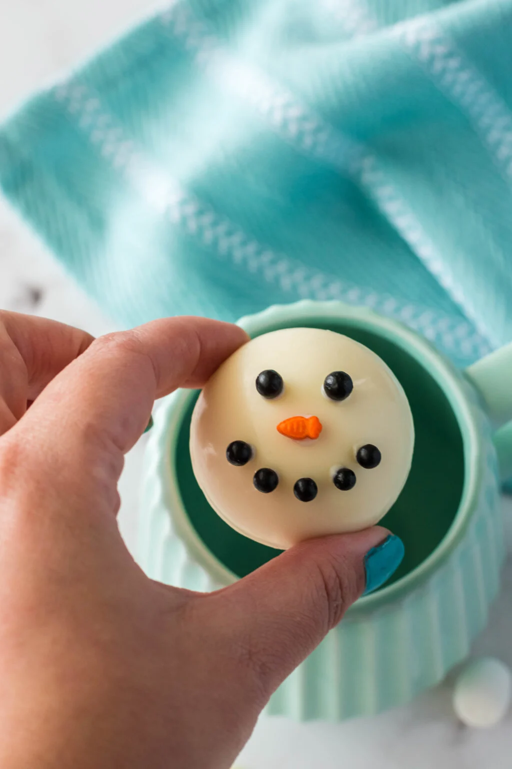 snowman hot chocolate bomb over a mug