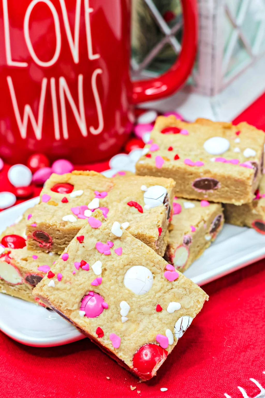valentine cookie bars with valentine sprinkles and M&Ms cut on a plate