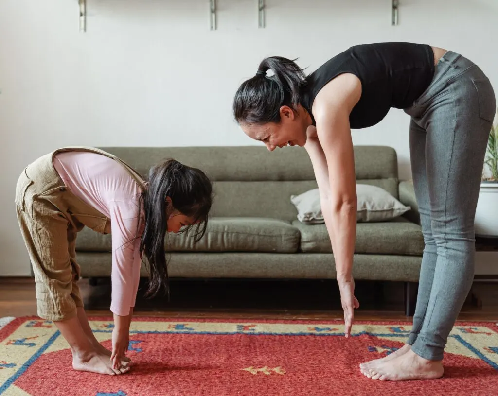 mom and daughter stretching at home