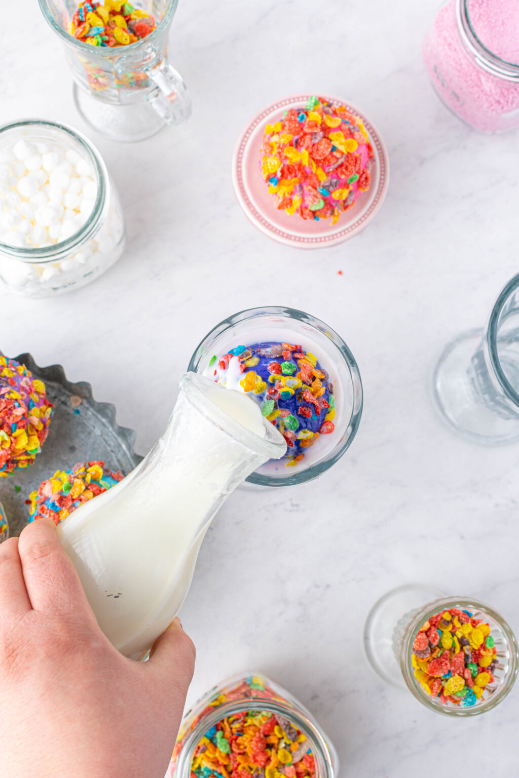 milk being poured over fruity pebbles hot cocoa bomb
