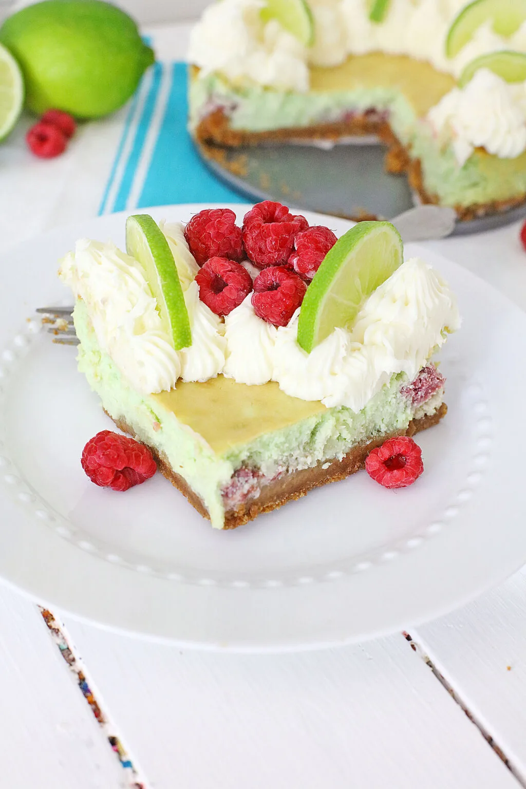 raspberry lime cheesecake slice on a white plate