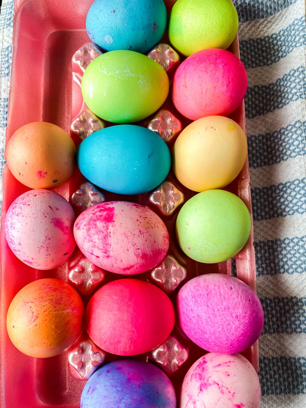 top view of brightly dyed easter eggs in egg carton