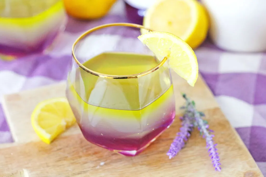 lavender lemon cocktail in a glass with lemon garnish