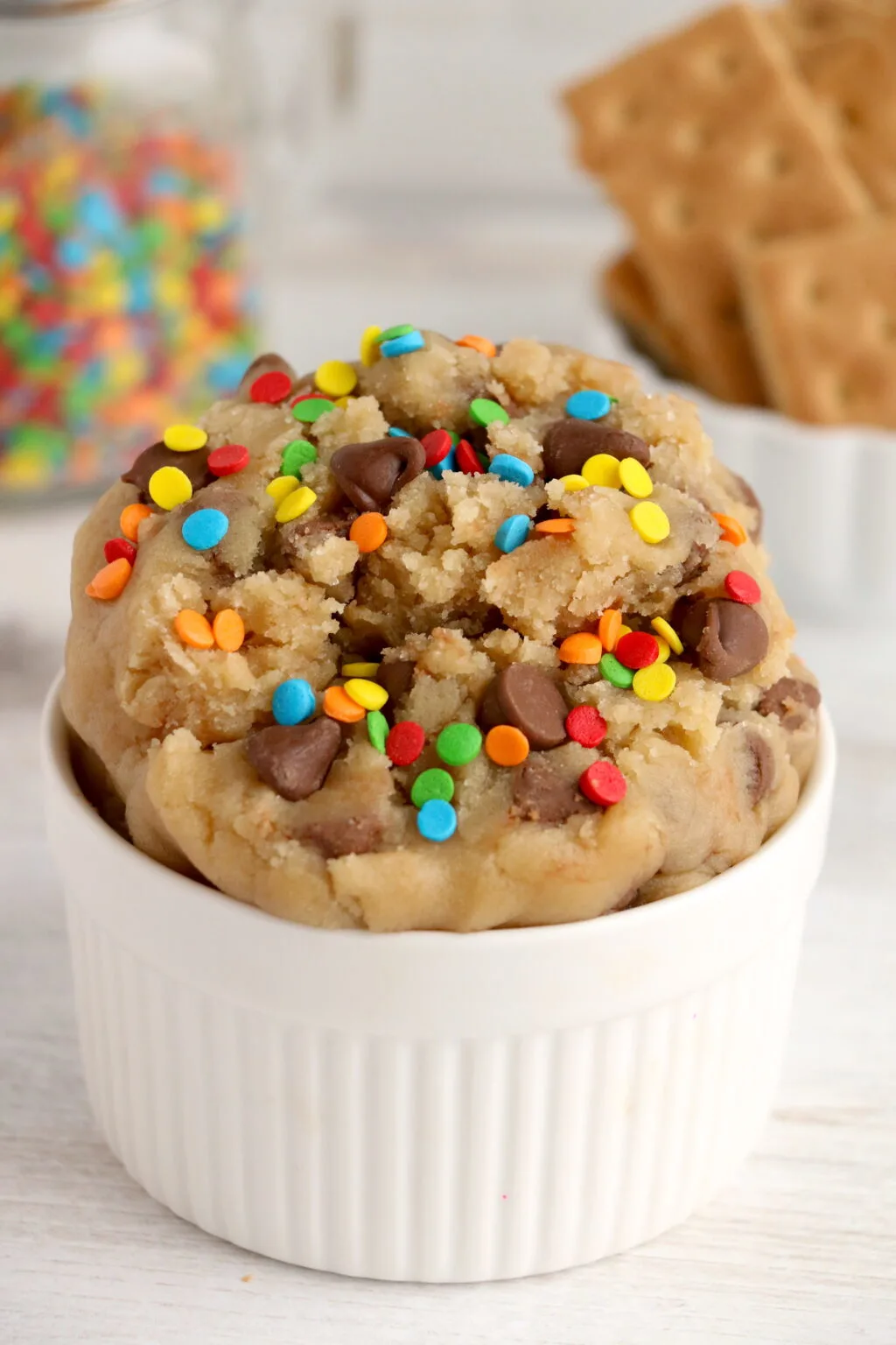 up close of edible chocolate chip cookie dough with rainbow sprinkles on top