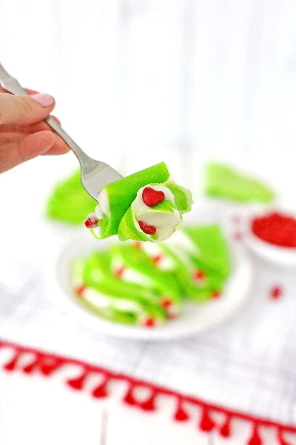 piece of bright green grinch crepes on a fork ready to take a bite