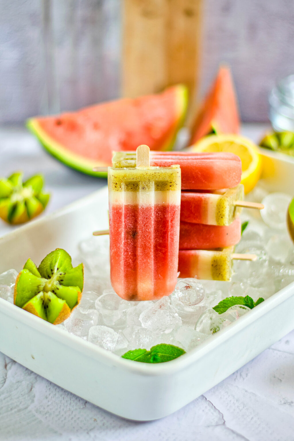 homemade watermelon popsicles stacked on ice