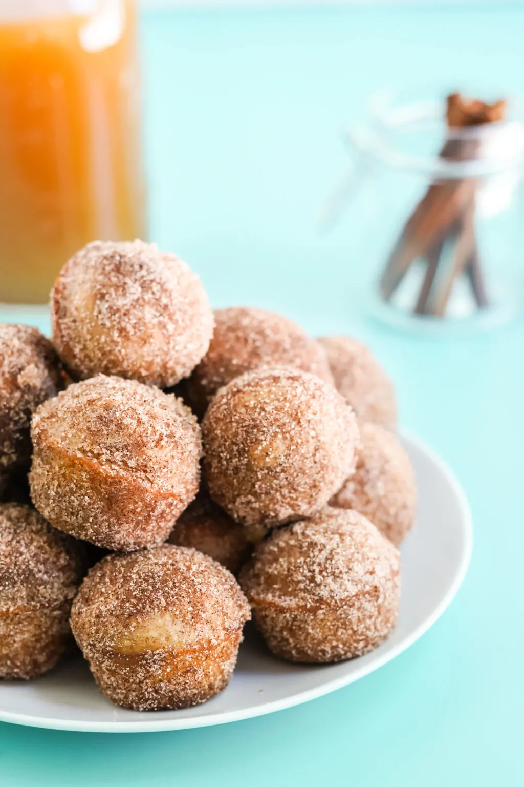 apple cider donut holes stacked on a white plate