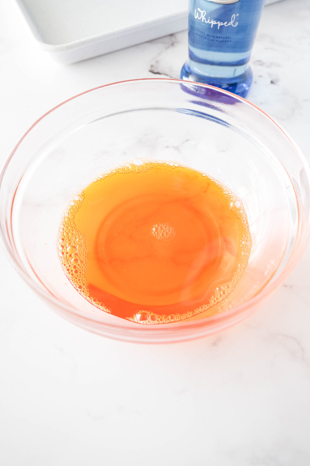 orange jello mixture in a clear glass bowl