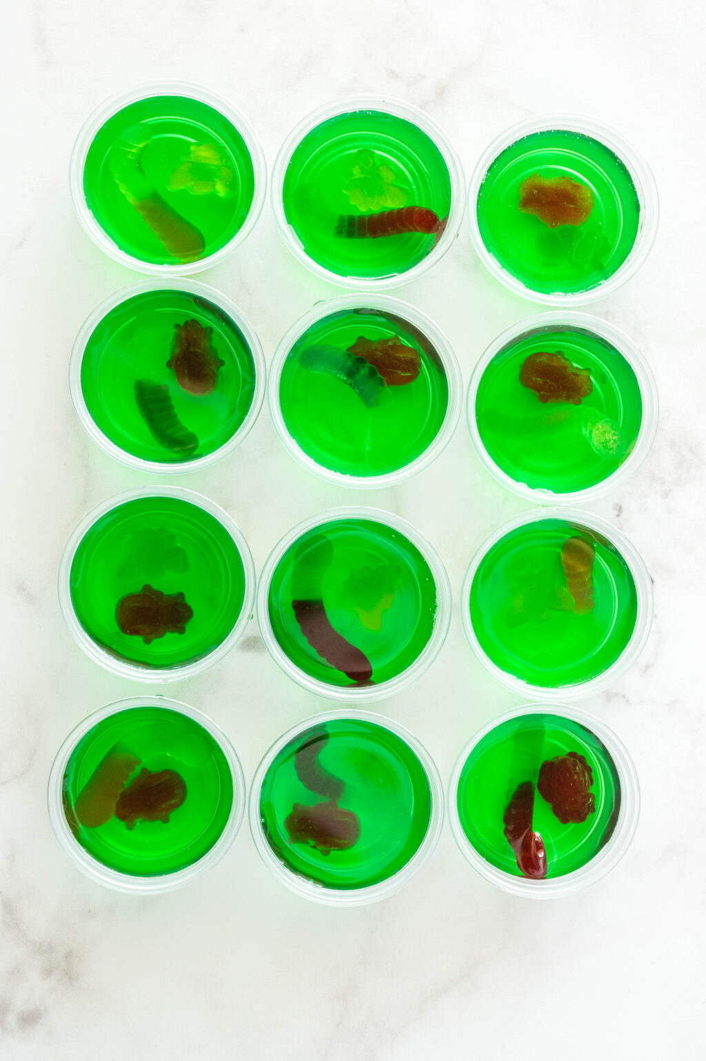 cups filled with green jello and gummy candies