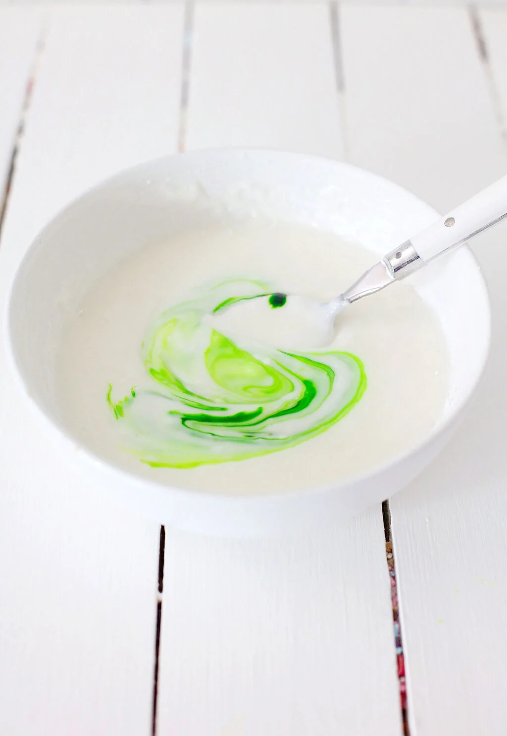 frosting with green food coloring in bowl