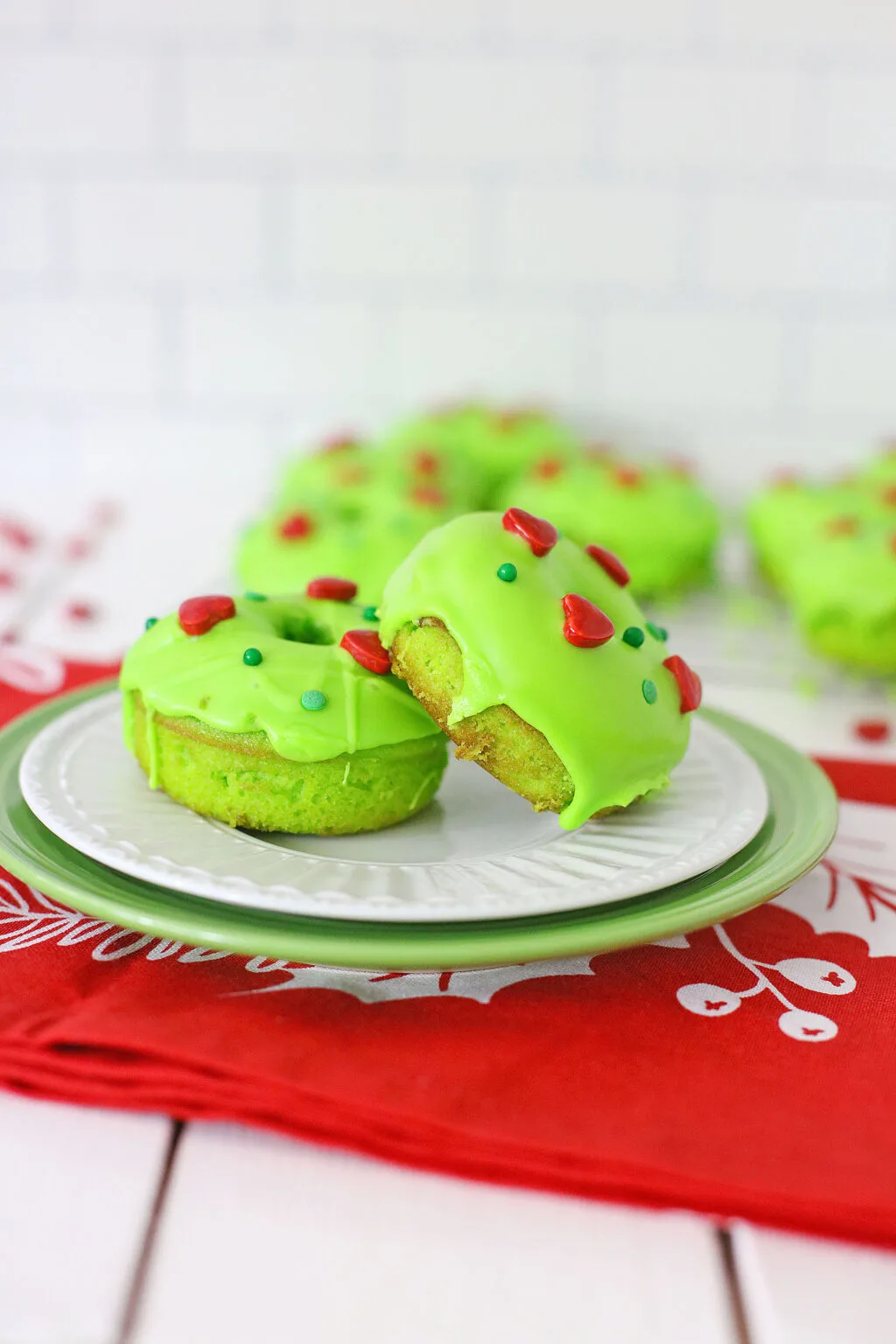 two grinch donuts side by side on a white plate