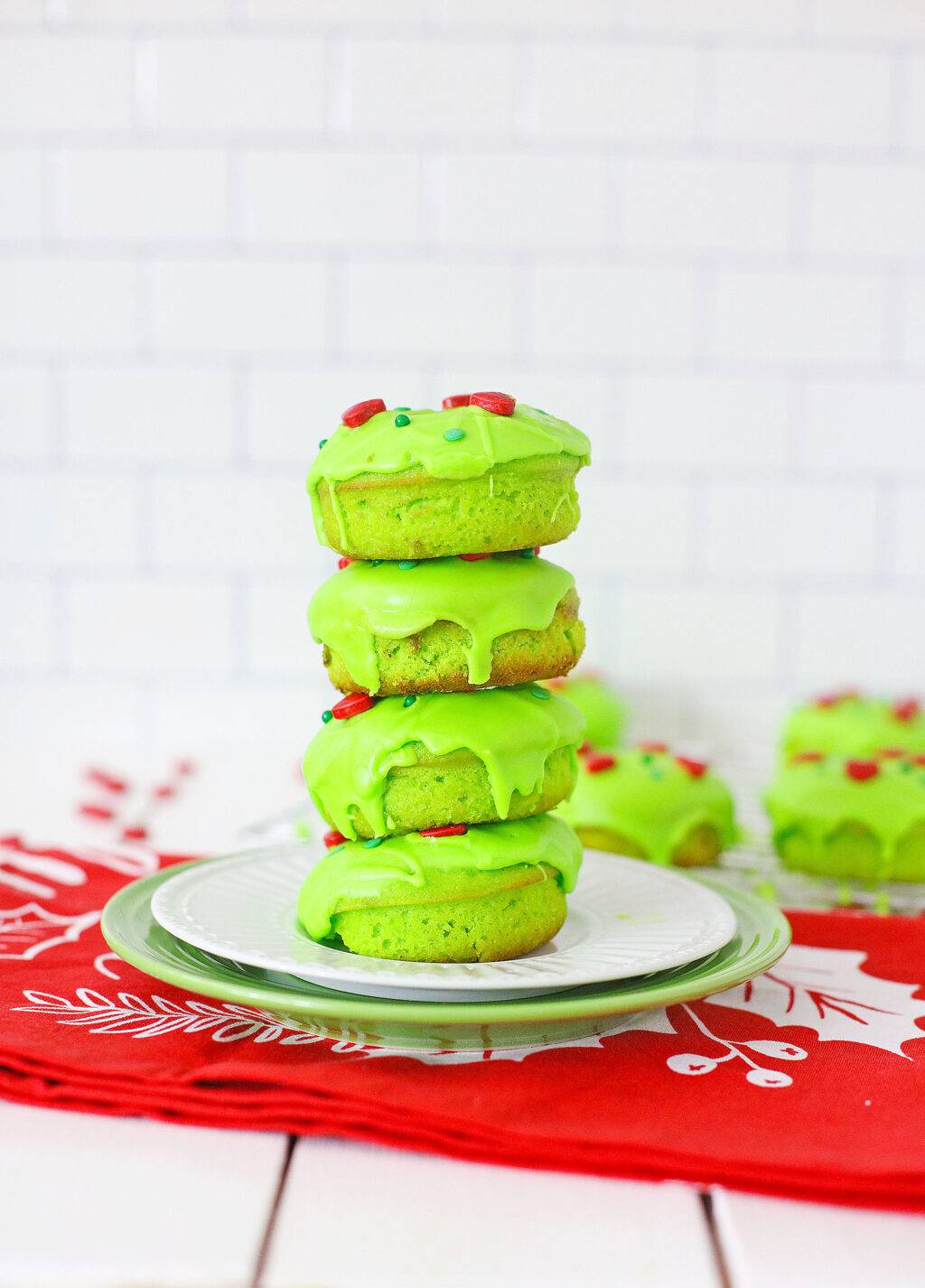 grinch donuts stacked on a white plate