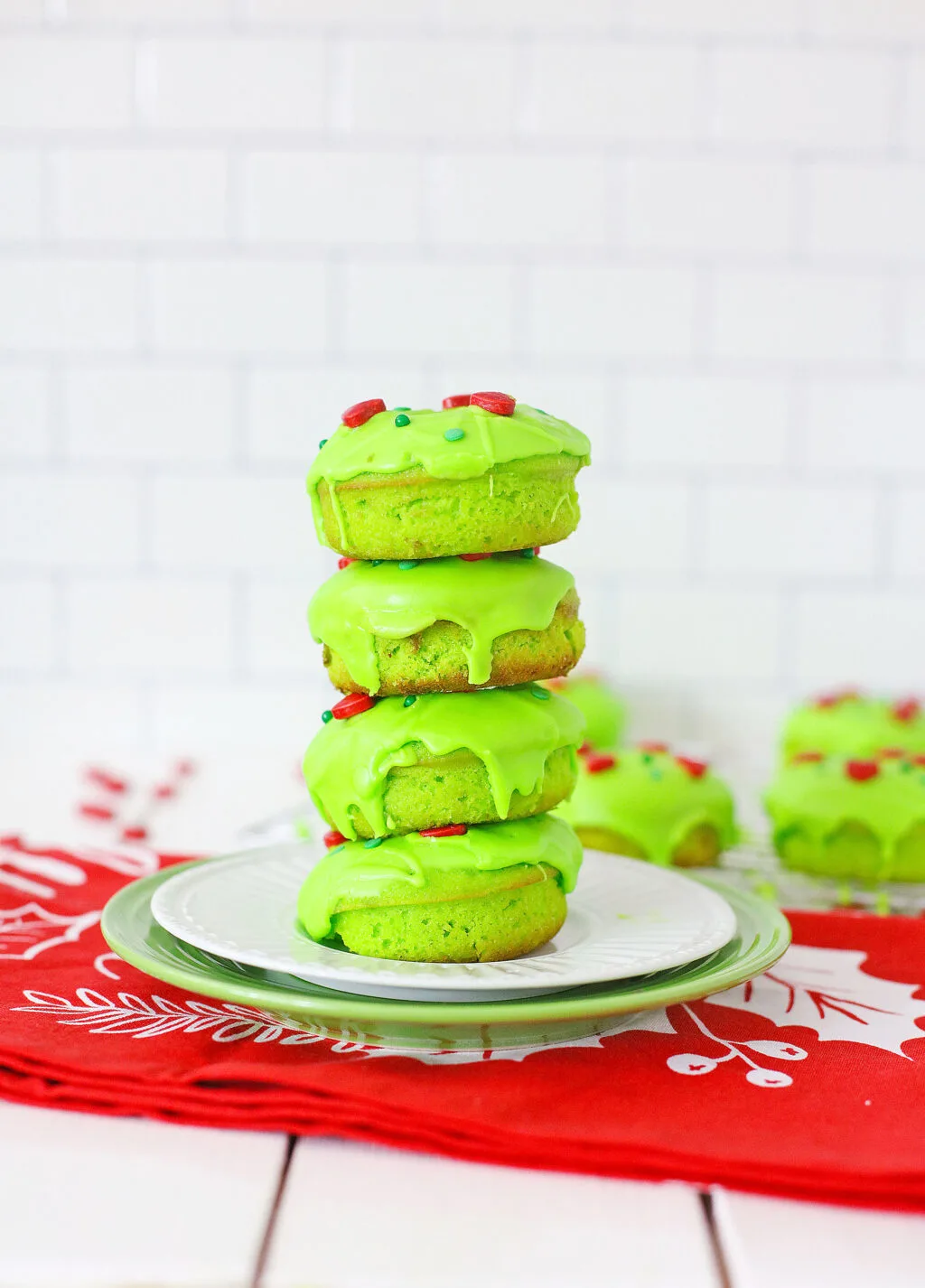 grinch donuts stacked on a white plate