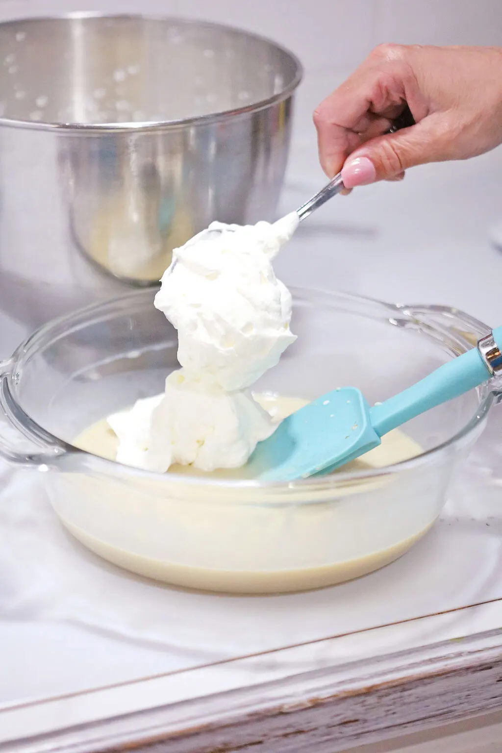whipped cream being put into glass bowl