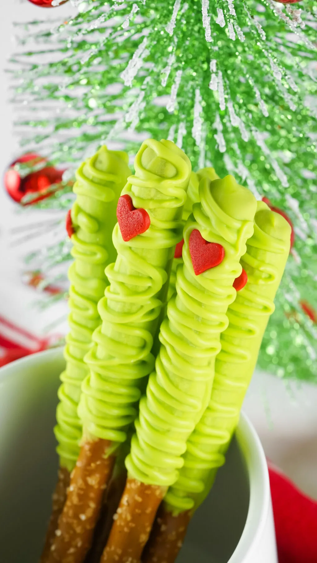 up close of grinch pretzels in a white cup