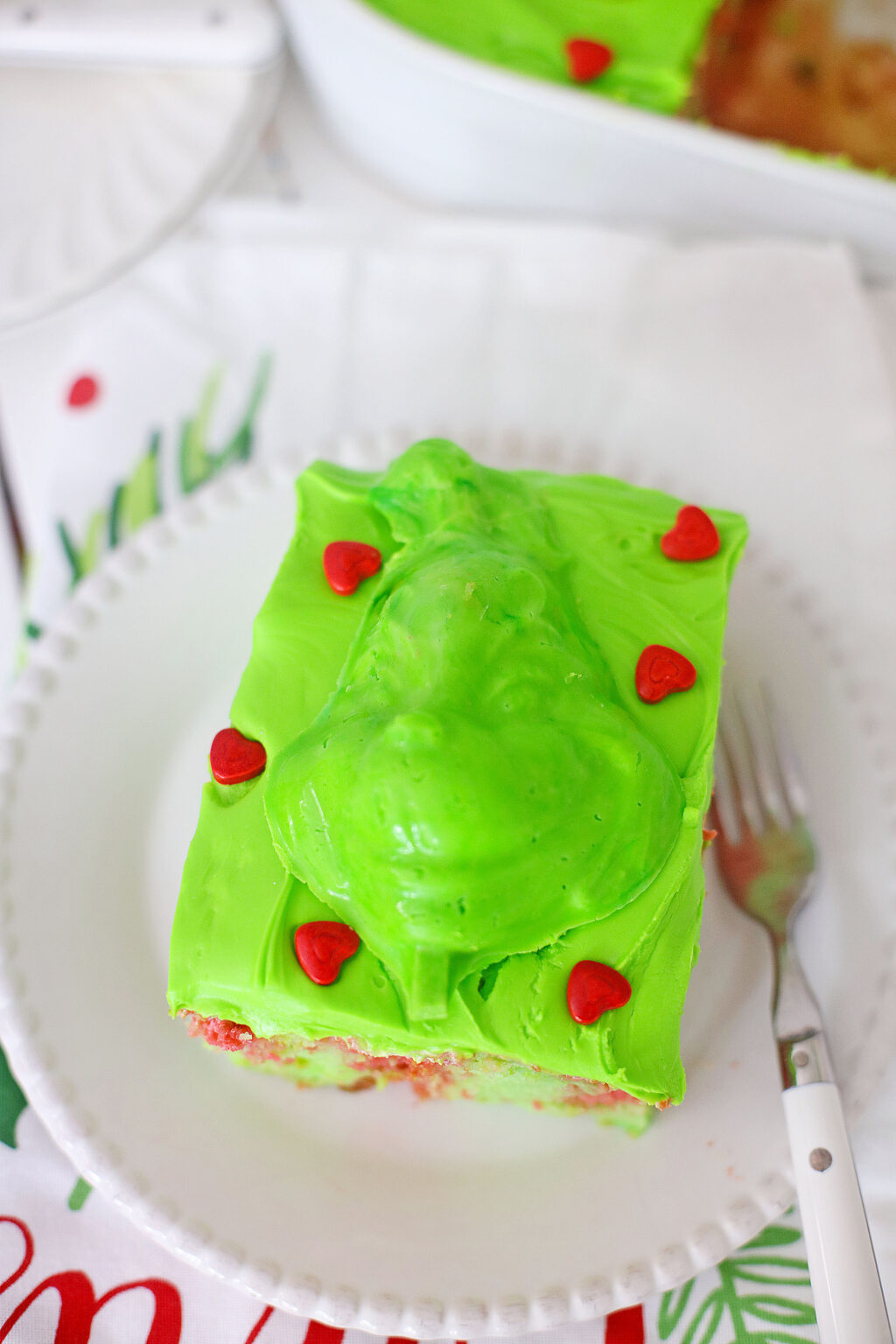 slice of grinch cake on a white plate with a fork