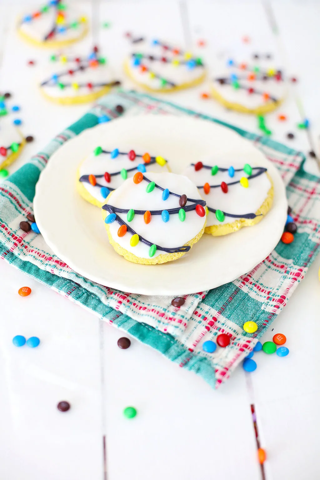 christmas lights cookies on a white plate with M&Ms around it