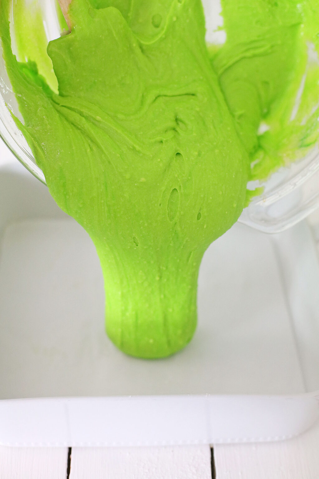 green brownie batter being poured into baking pan
