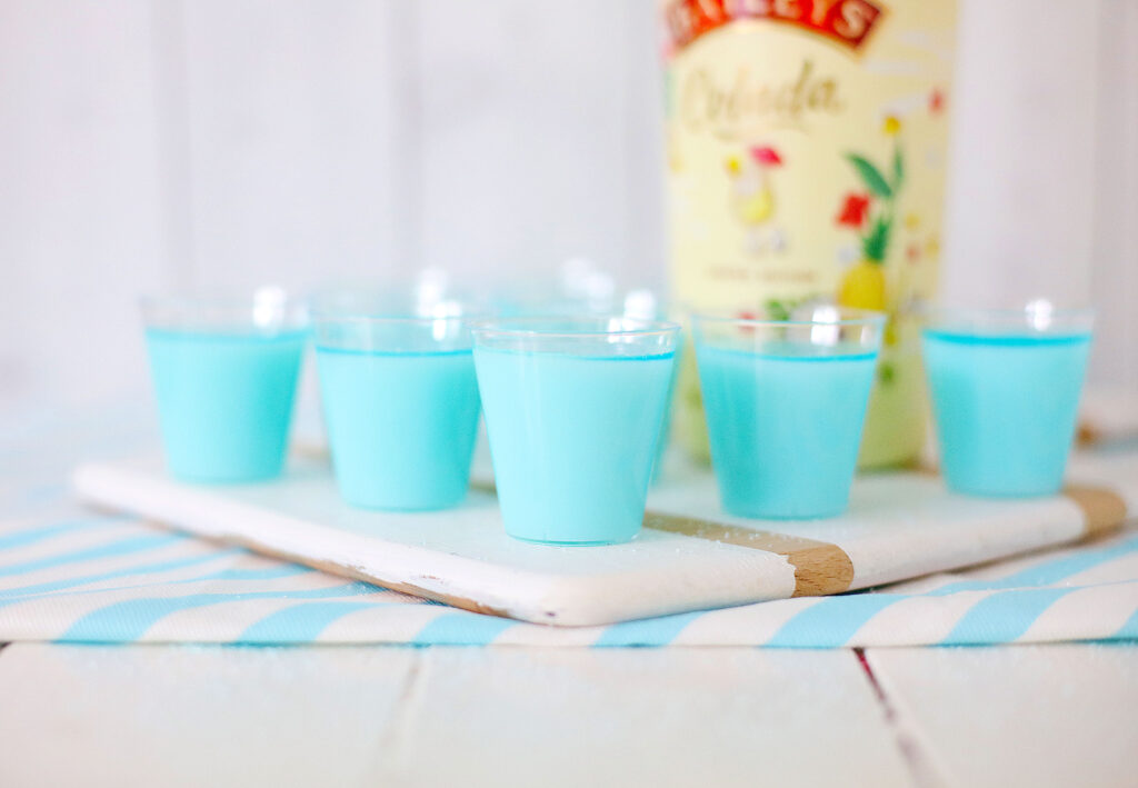 several shot glasses of blue hawaiian jello shots on table