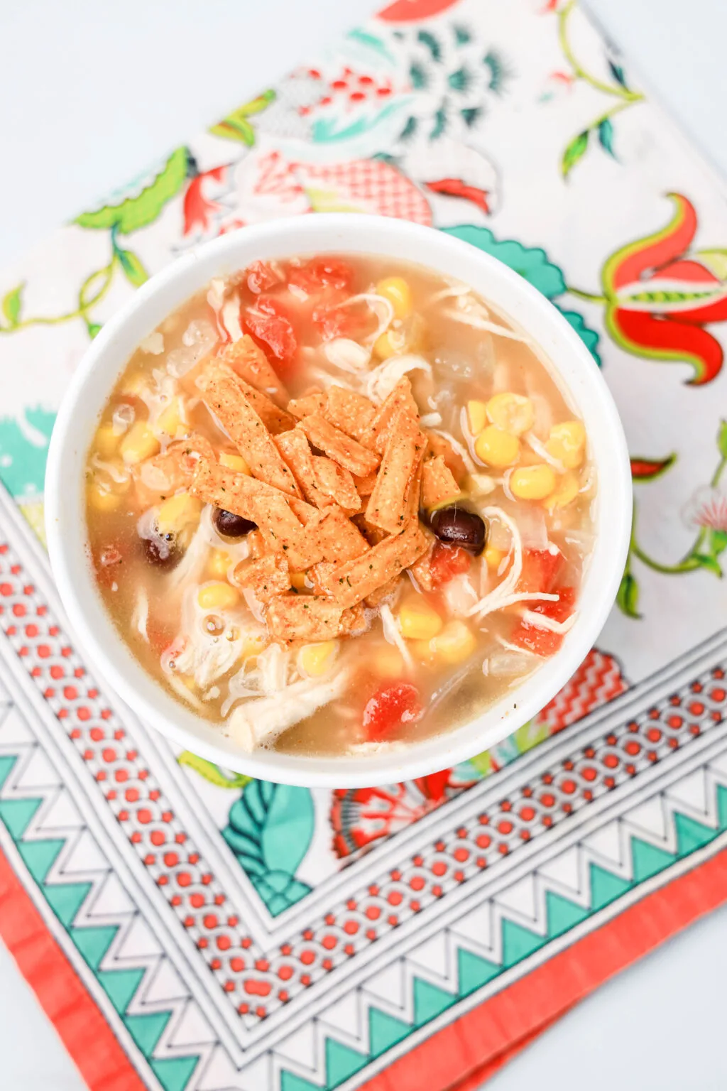 a white bowl of chick-fil-a chicken tortilla soup on a colorful napkin
