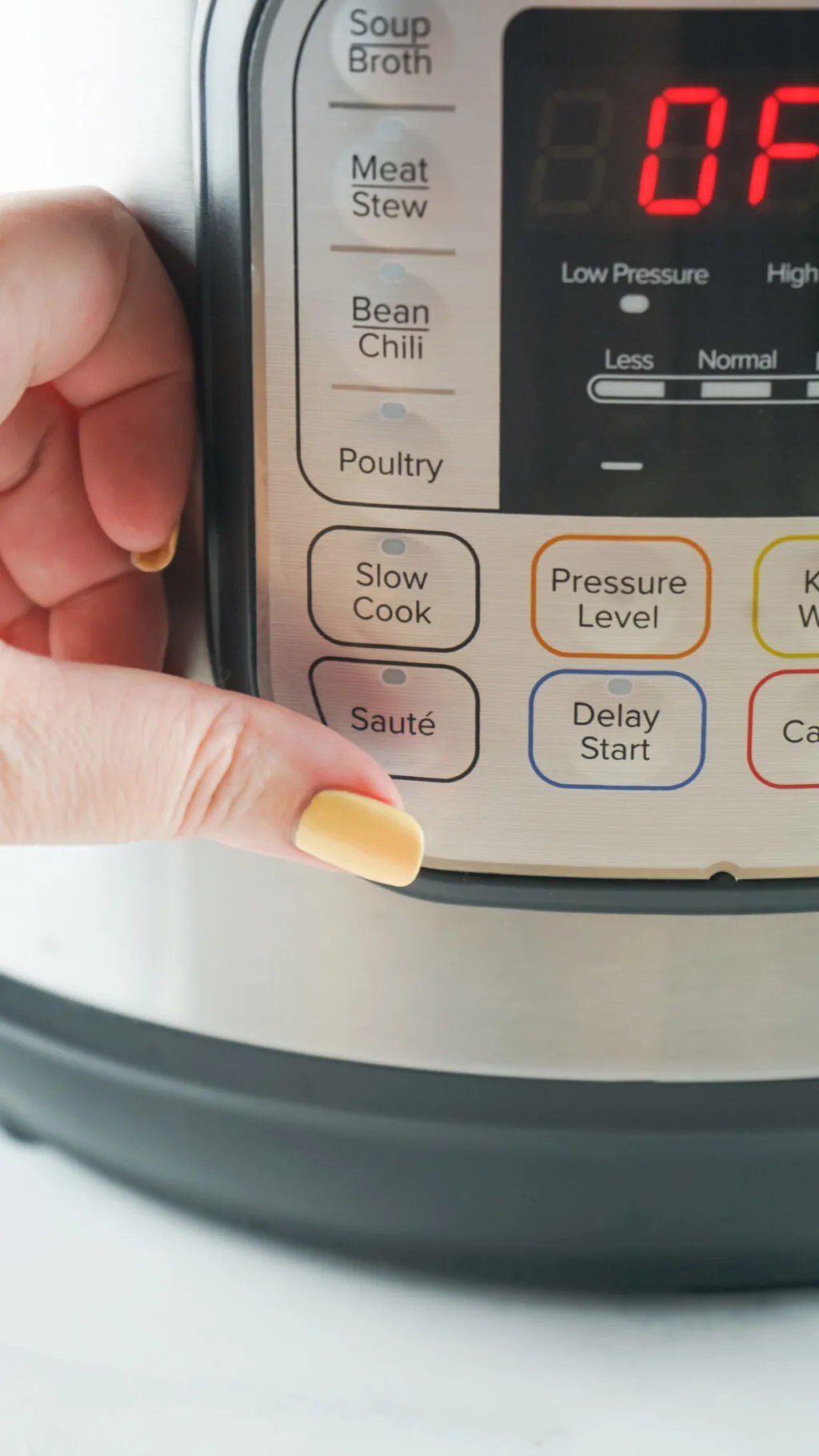 woman pushing the saute button on an instant pot