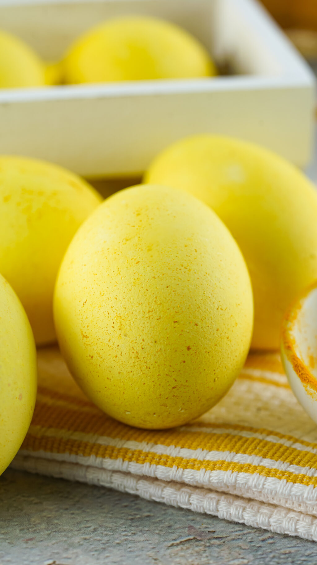 upclose of naturally dyed yellow egg with speckles of turmeric on top