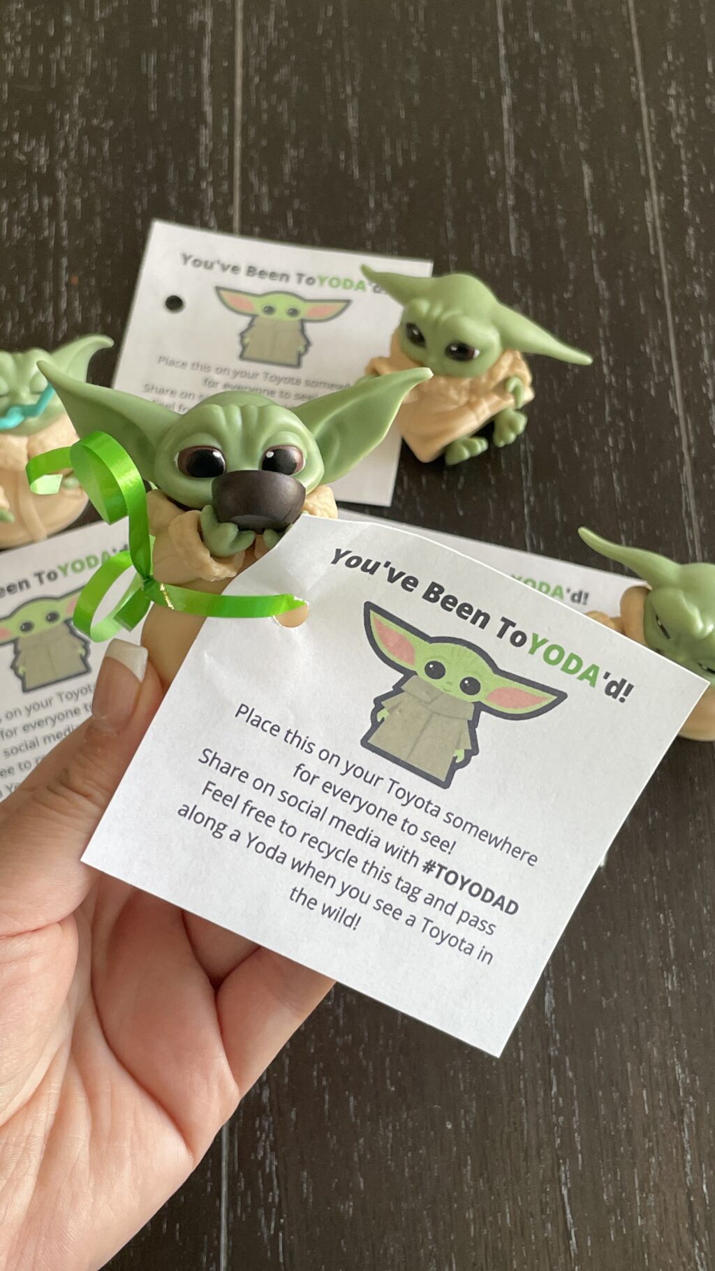 hand holding baby yoda with tag attached