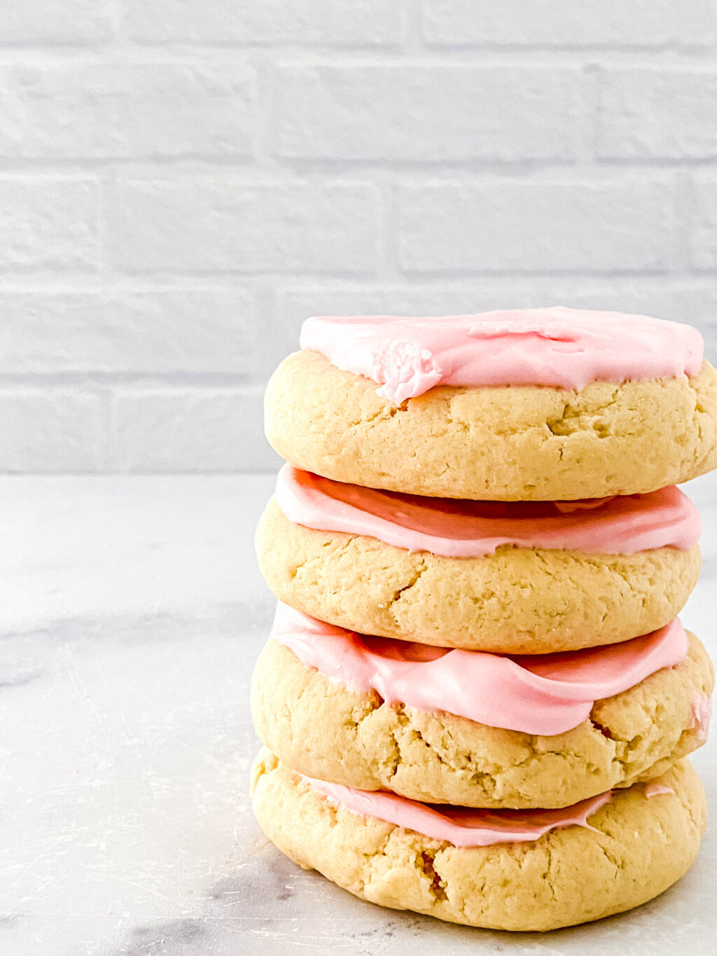 pink sugar cookies stacked on table