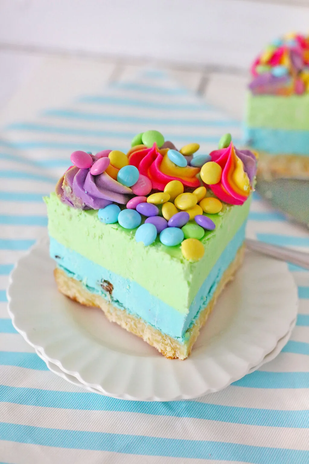 slice of easter cheesecake on a white plate with a blue striped napkin