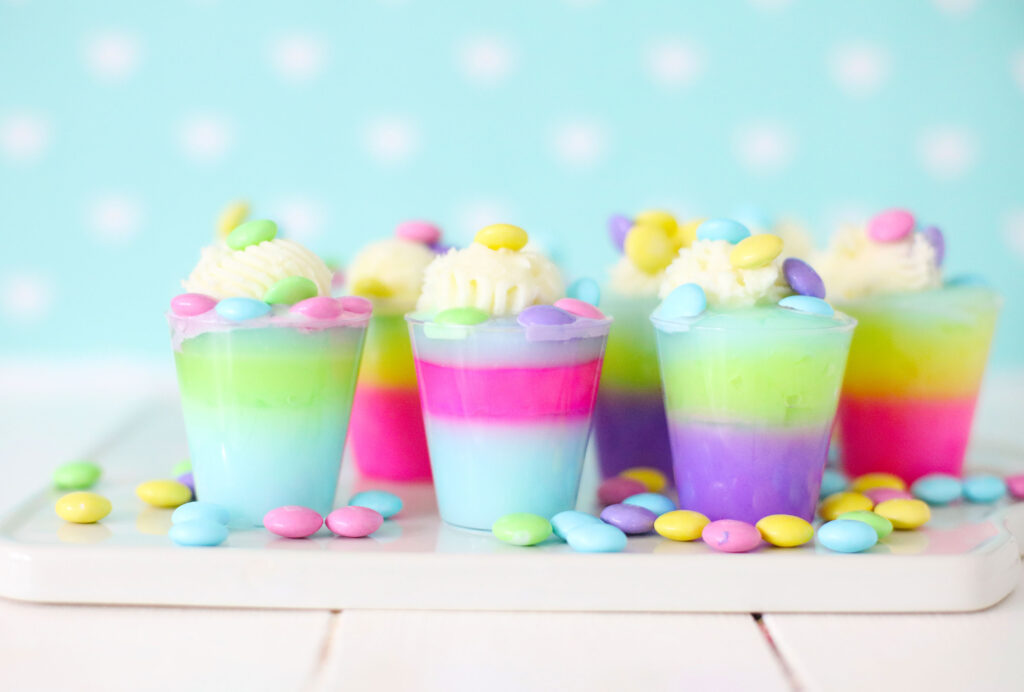 several easter jello shots with easter M&ms scattered on table