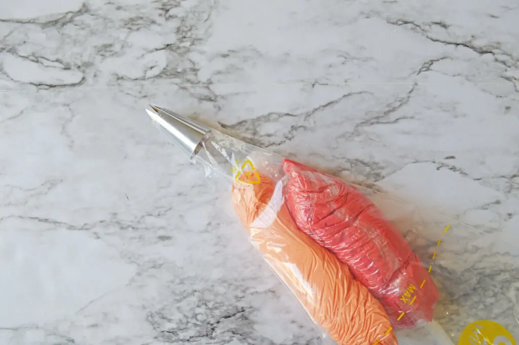 bag of red and orange frosting with decorating tip