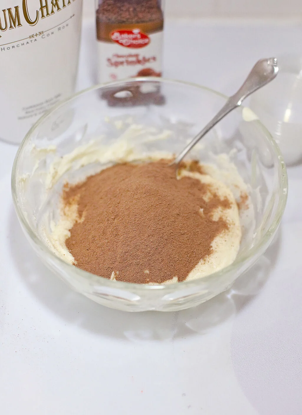 cocoa powder on top of cream cheese in clear bowl