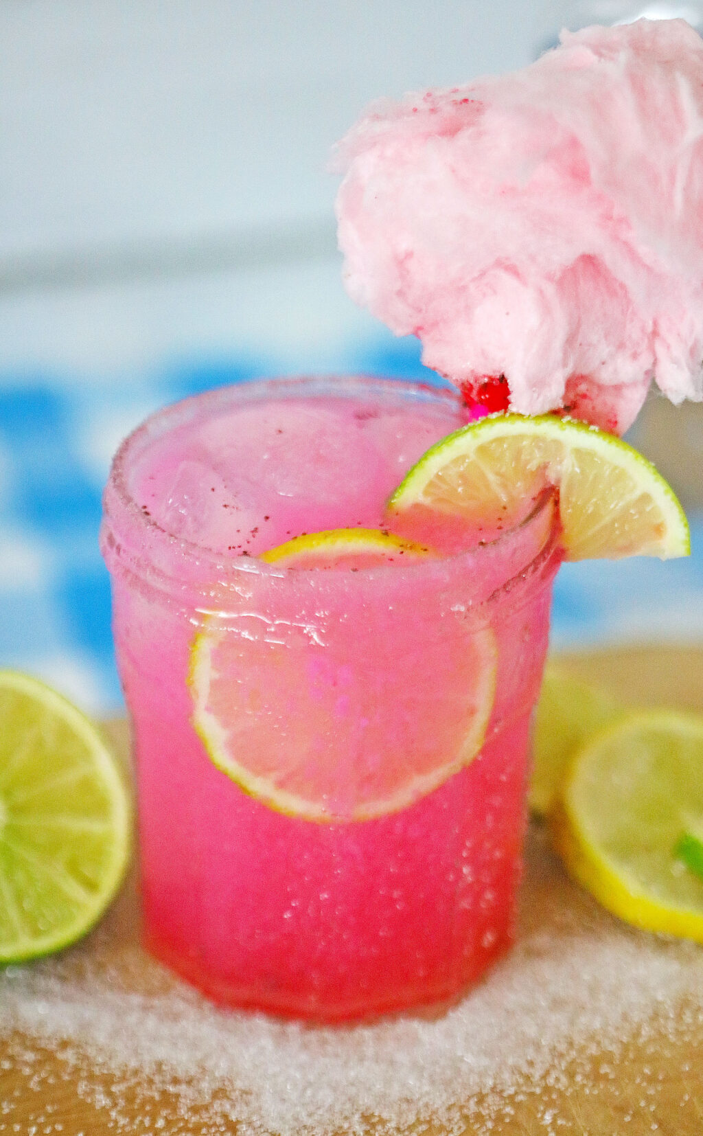 cotton candy margarita in a glass with pink cotton candy on top
